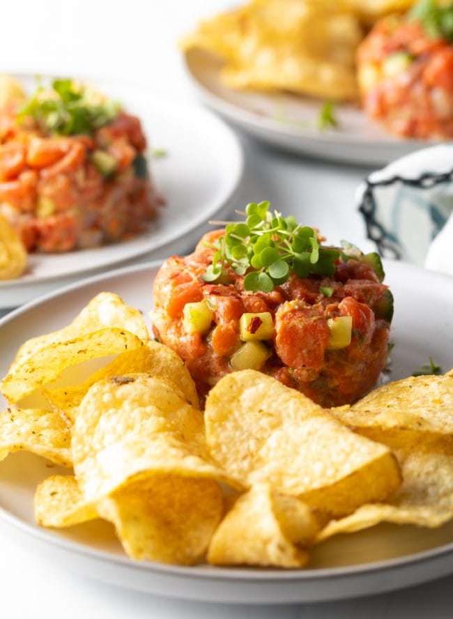 salmon tartare - poke recipe with potato chips on a plate