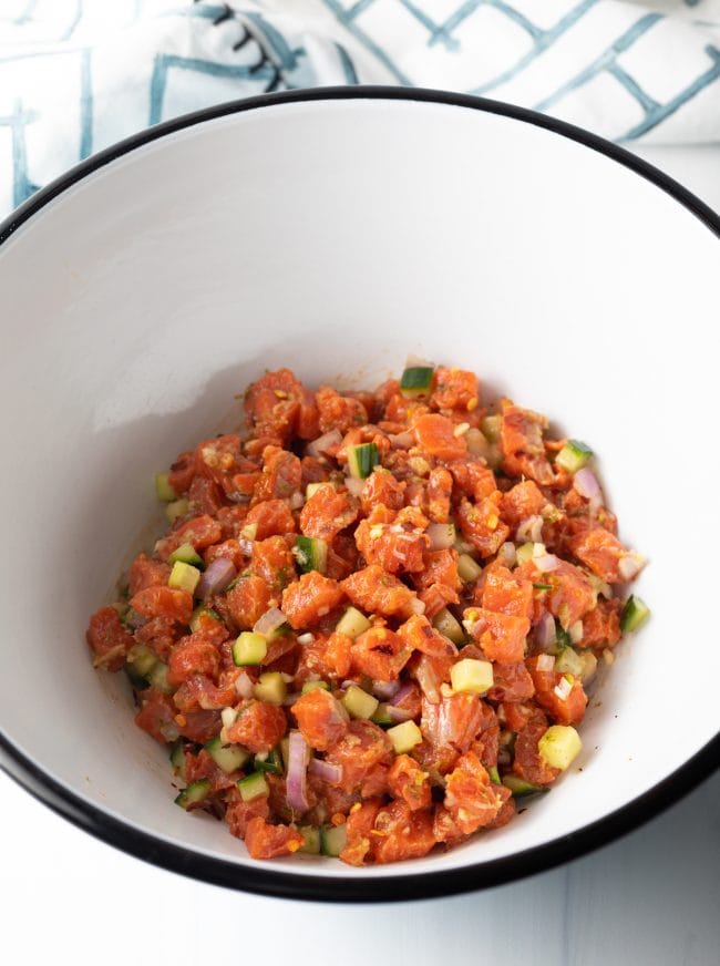 all of the salmon poke ingredients combined in a mixing bowl