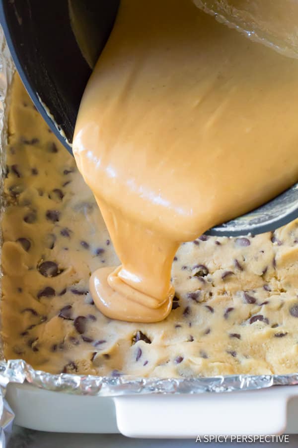How to make Chocolate Chip Cookie Bars, with gooey caramel centers. This cookie bar recipe is so delicious, everyone will ask for the recipe. #ASpicyPerspective #cookiebars #cookies #chocolatechip #baking #dessert