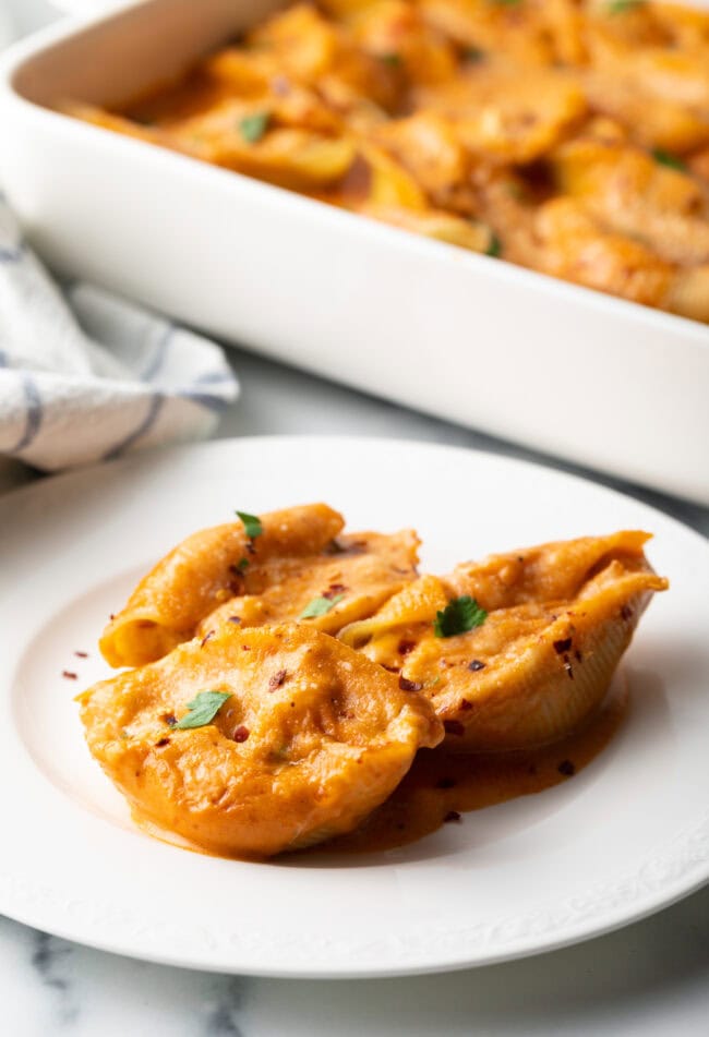 Serving of cheesy seafood pasta on a white plate.