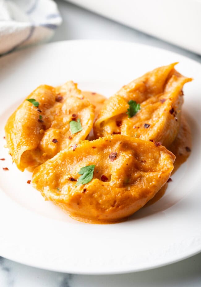 Serving of cheesy seafood pasta on a white plate.