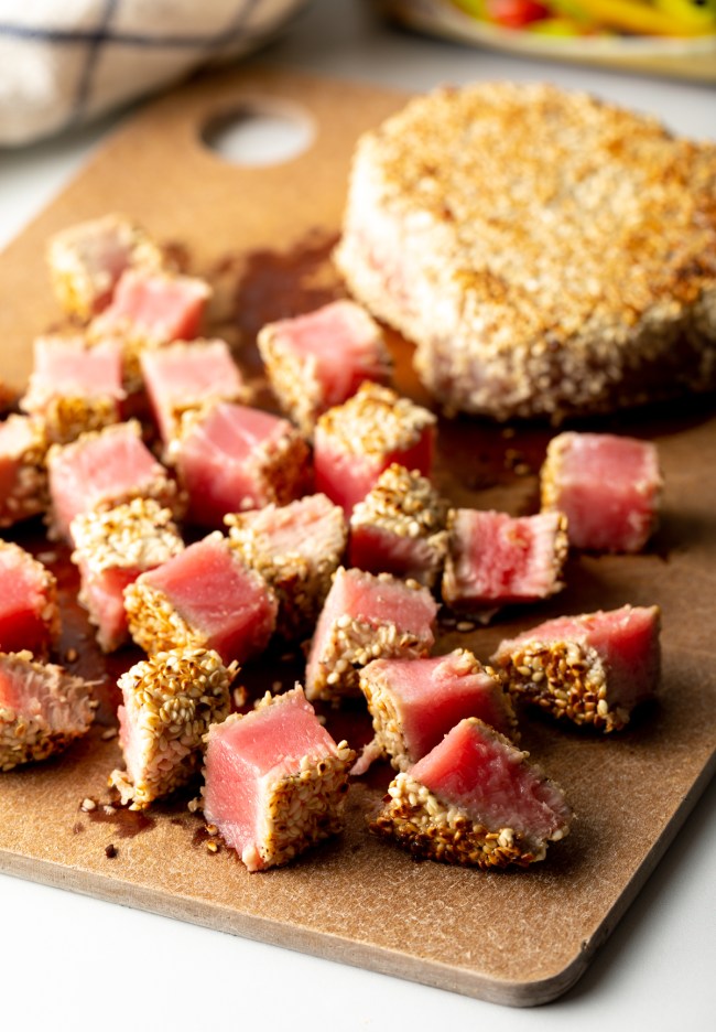 cubed seared sesame crusted tuna on a cutting board