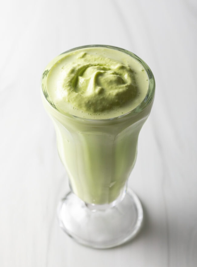 Light green colored mint milkshake in a glass.