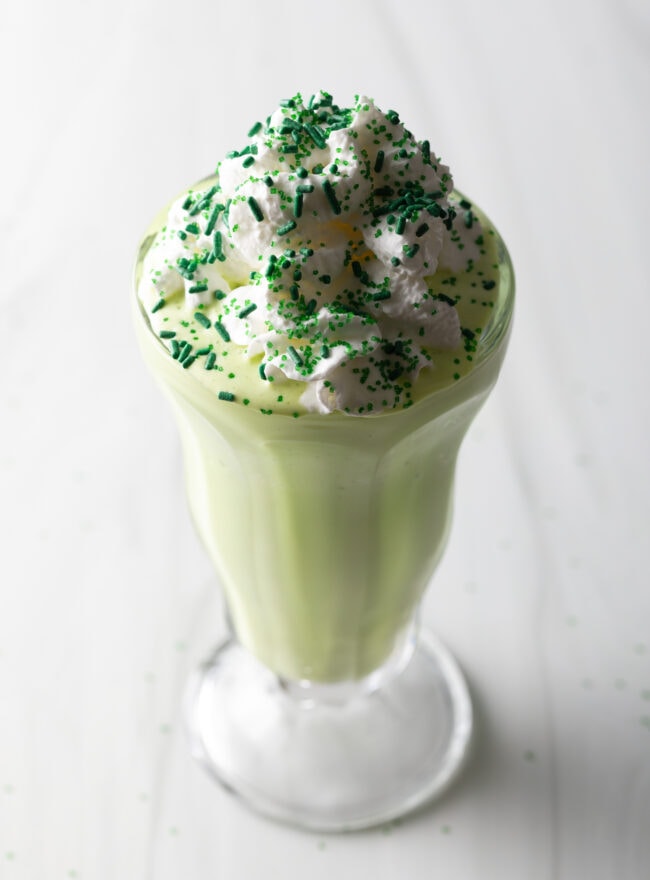 Milkshake covered in green sprinkles.