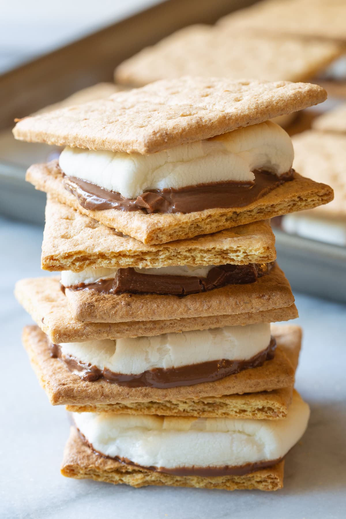 Baked s'mores sandwiches stacked on top of each other. 