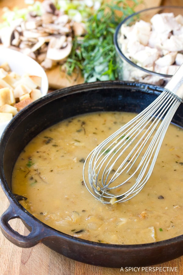 Gravy in a skillet with a whisk. 