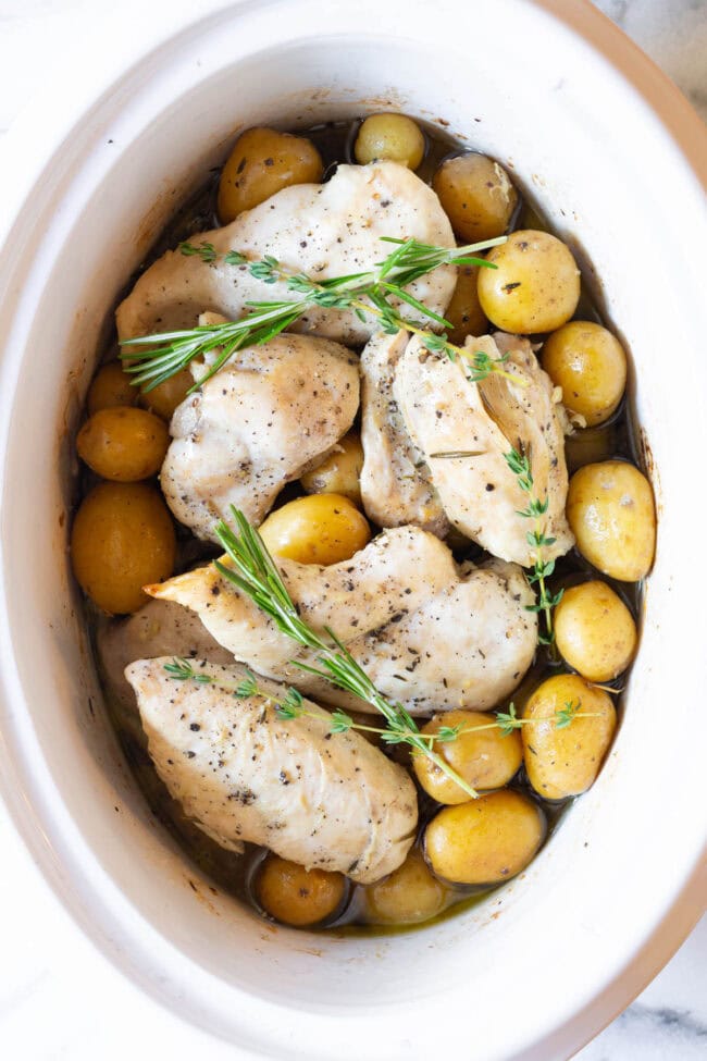 Garlic butter chicken and potatoes in the crockpot after being cooked. 