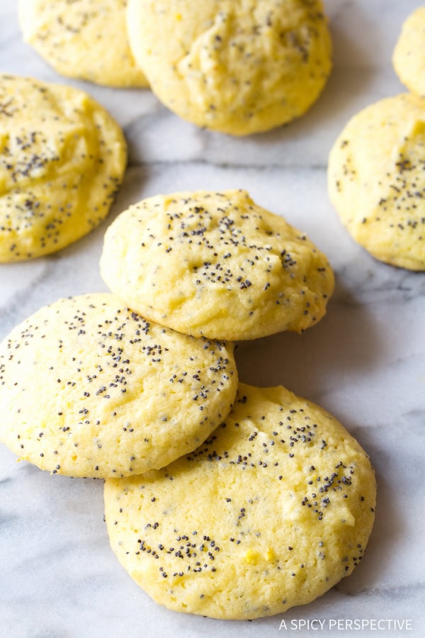 Lemon poppy seed cookies scattered on a kitchen counter. 