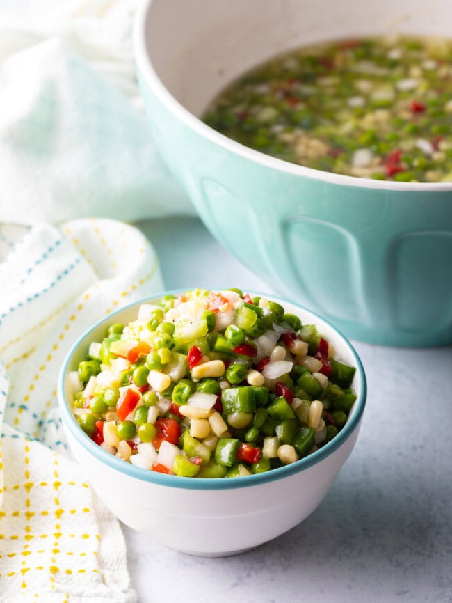 Top down view white bowl with marinated vegetable salad.