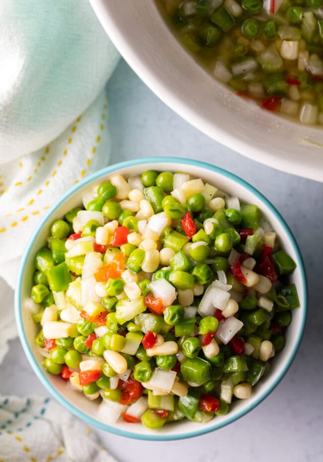 Top down view white bowl with marinated vegetable salad.