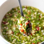 Metal spoon showing scoop of veggie salad to camera.