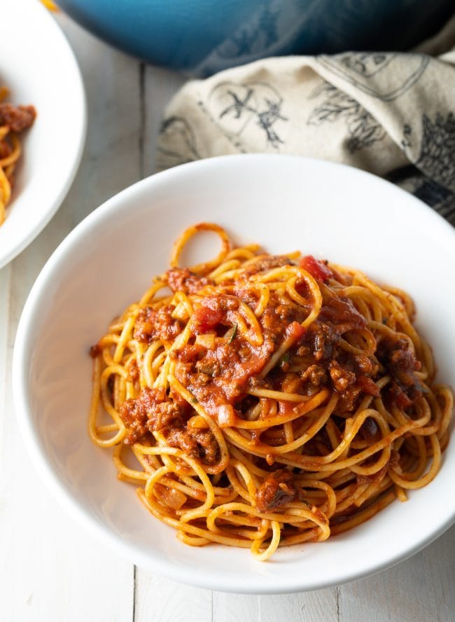 Spaghetti and meat sauce served in a white bowl. 