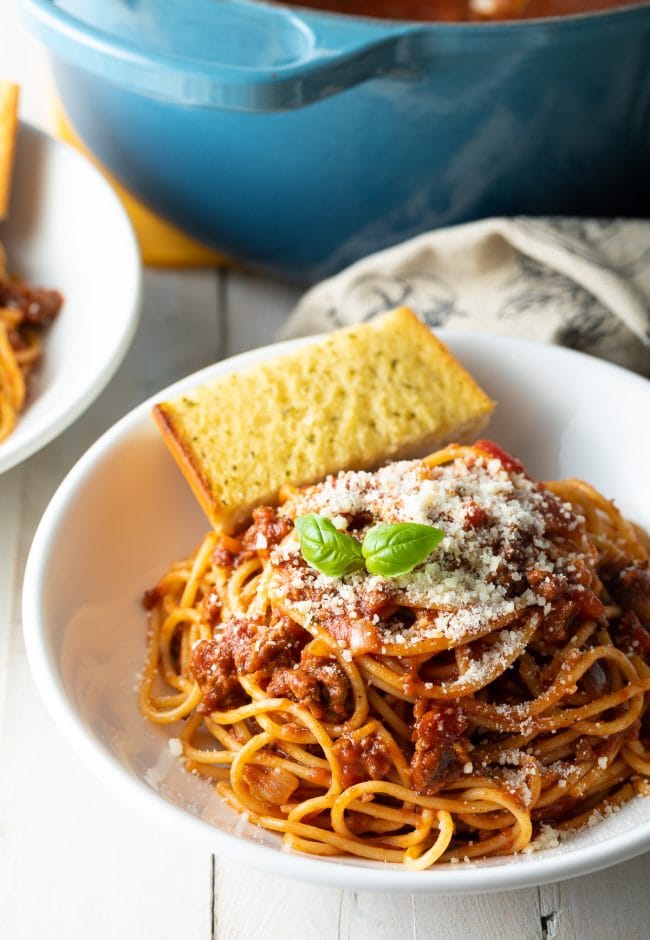 Spaghetti served with parmesan and basil on top. 