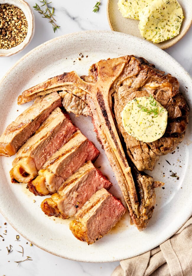 Porterhouse steak recipe with herb butter topping - cut on plate