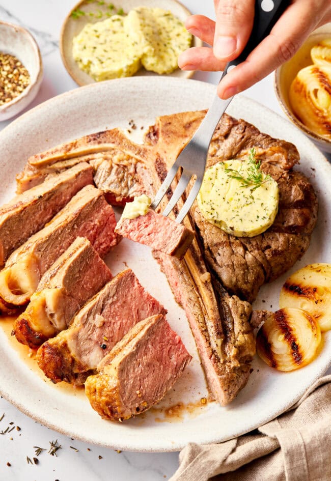 Steak with herb compound butter - fork lifting bite