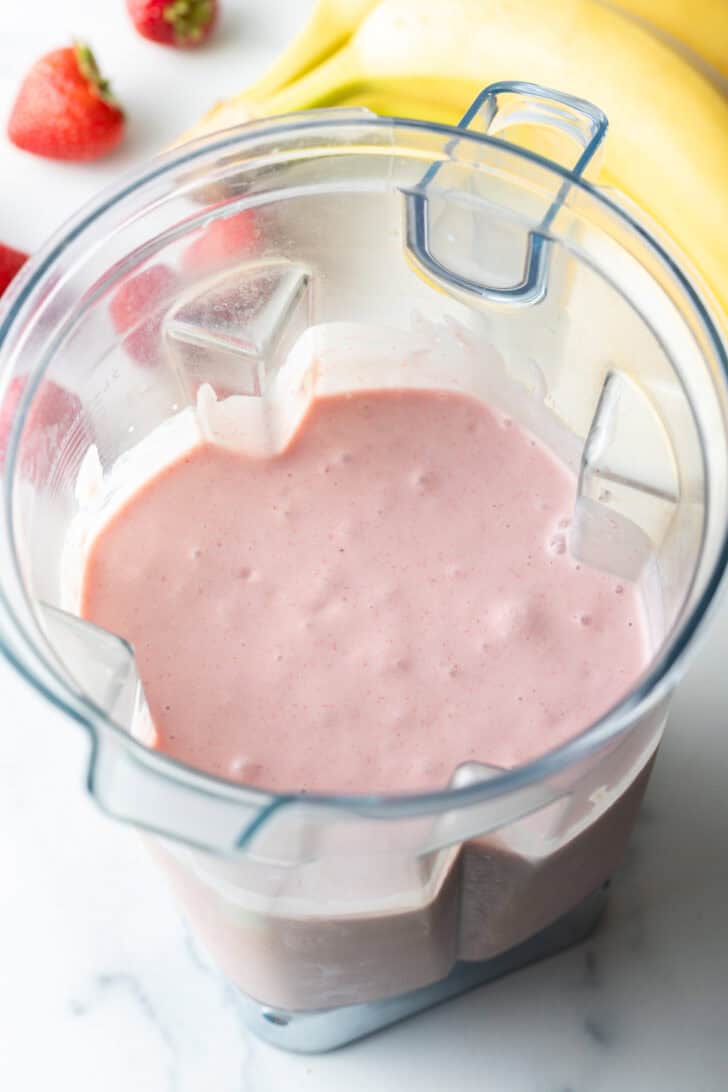 Pink smoothie in a blender jar.