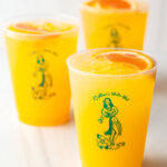 3 sunny d vodka seltzer drinks, each in a glass cup with slice of orange on top.