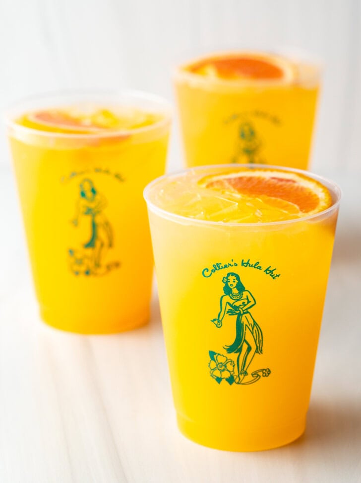 3 sunny d vodka seltzer drinks, each in a glass cup with slice of orange on top.