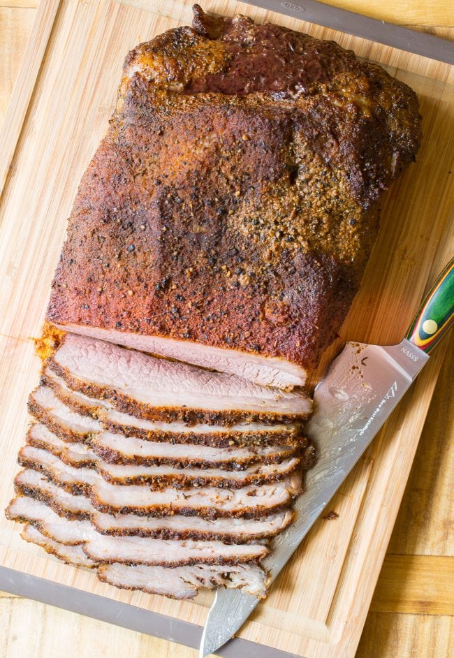 Texas beef brisket sliced against the grain on a cutting board. 