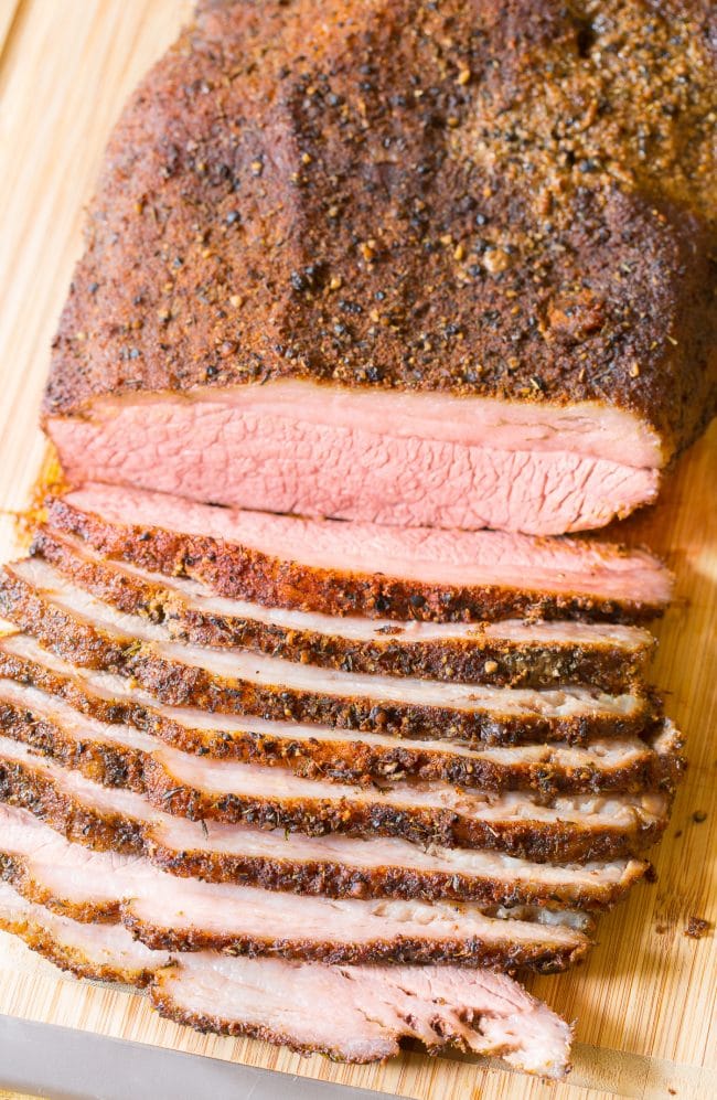 Sliced beef brisket (oven recipe) on a wooden cutting board.