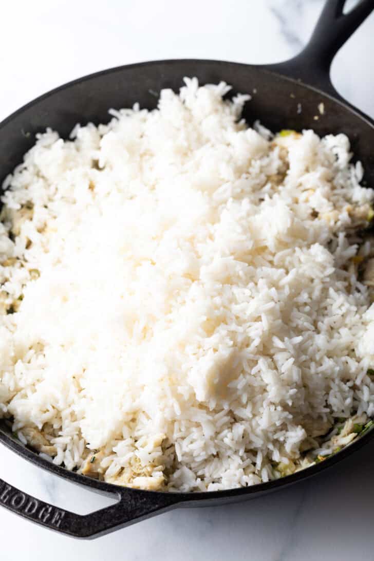 Cooked white rice in a black cast iron skillet.