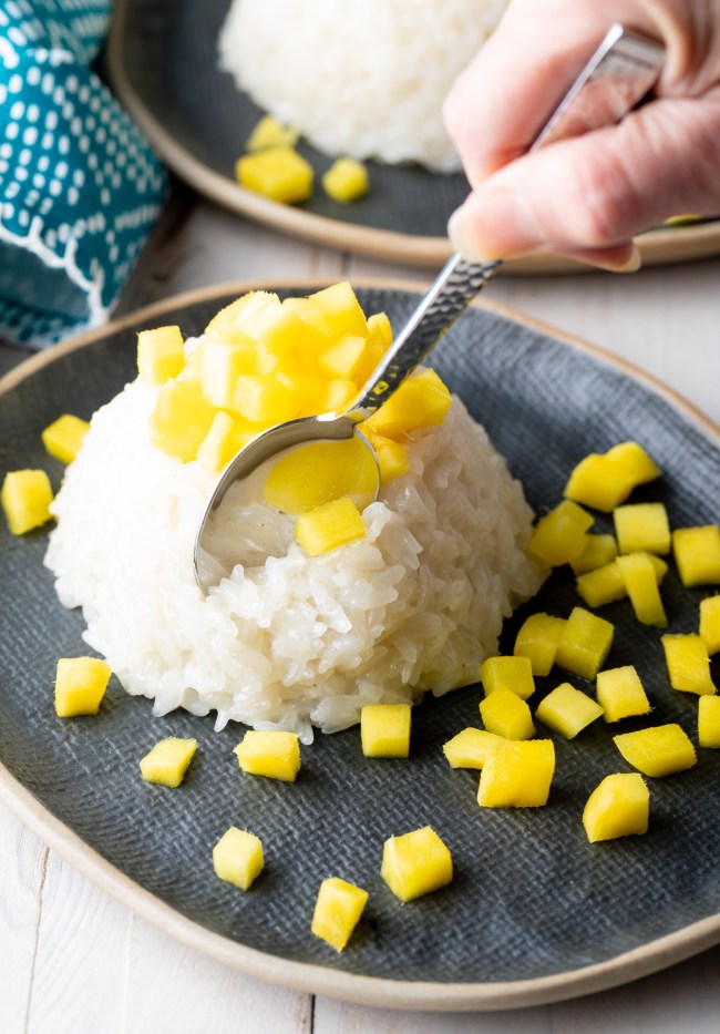 how to make coconut sticky rice with mangoes - spoon in pudding