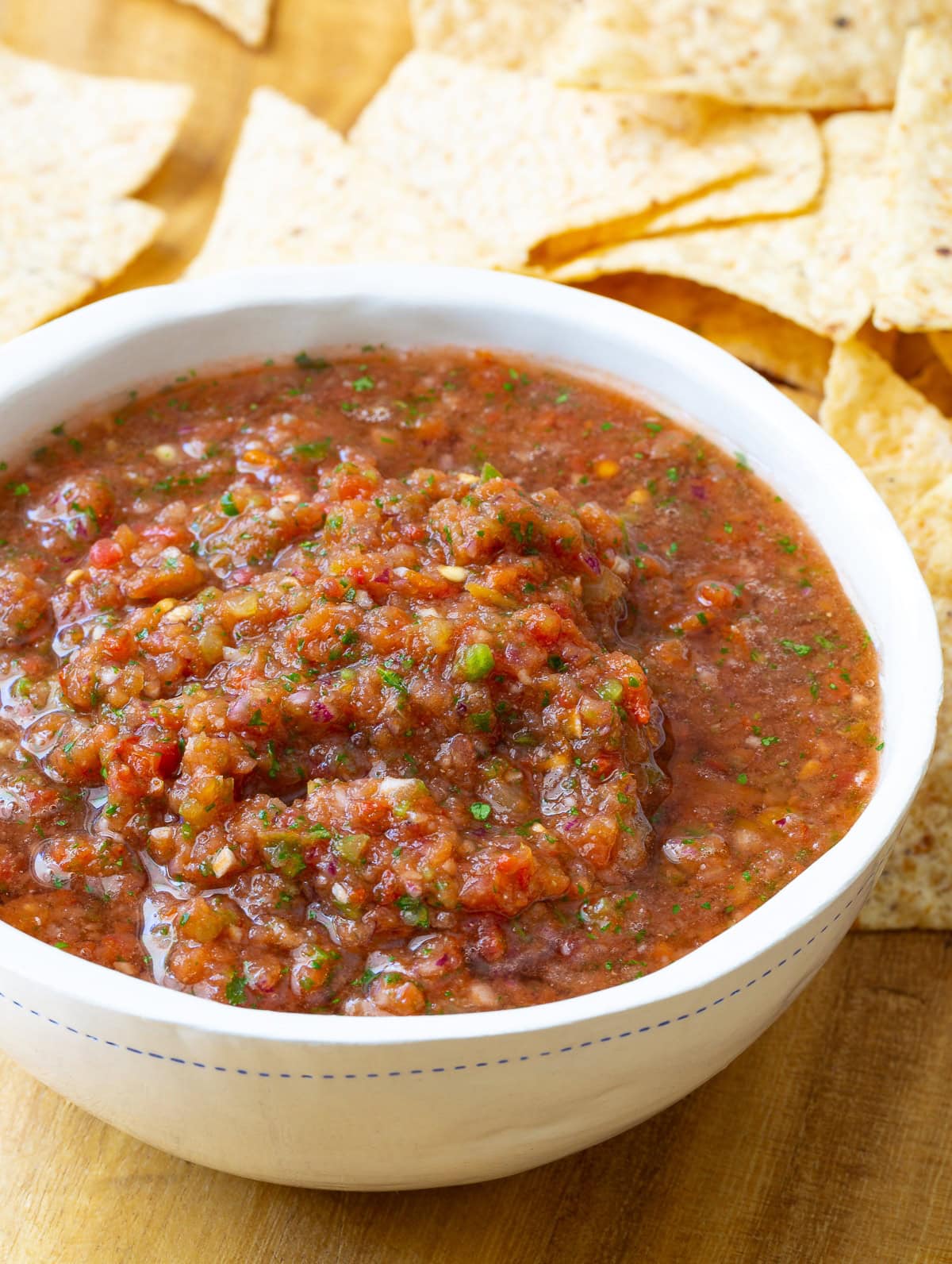 Tomato salsa shown in bowl with herbs and spices blended in. 