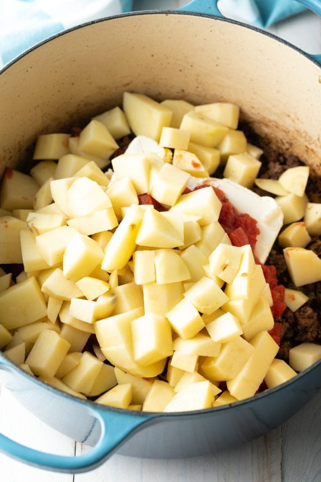 Potatoes and onions with cream cheese and beef in a pot. 