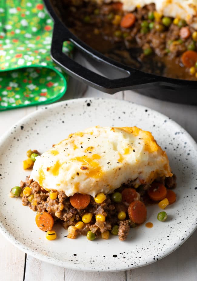 Irish Cottage Pie recipe (beef) on a plate with more in the background. 