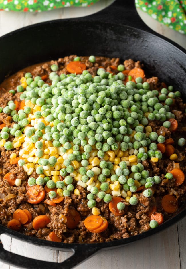 Cottage pie filling being cooked in a cast iron skillet. 