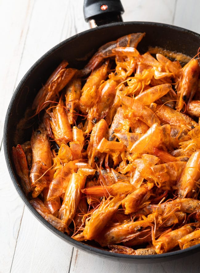 Making shrimp oil in a skillet with shrimp heads. 