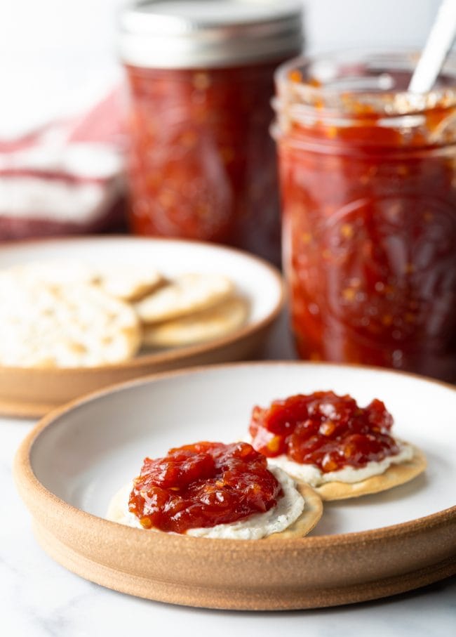 Side view of plate, with old-fashioned tomato jam on crackers and cheese.