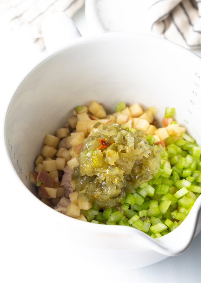 chopped apple, celery, and relish in a white measuring cup