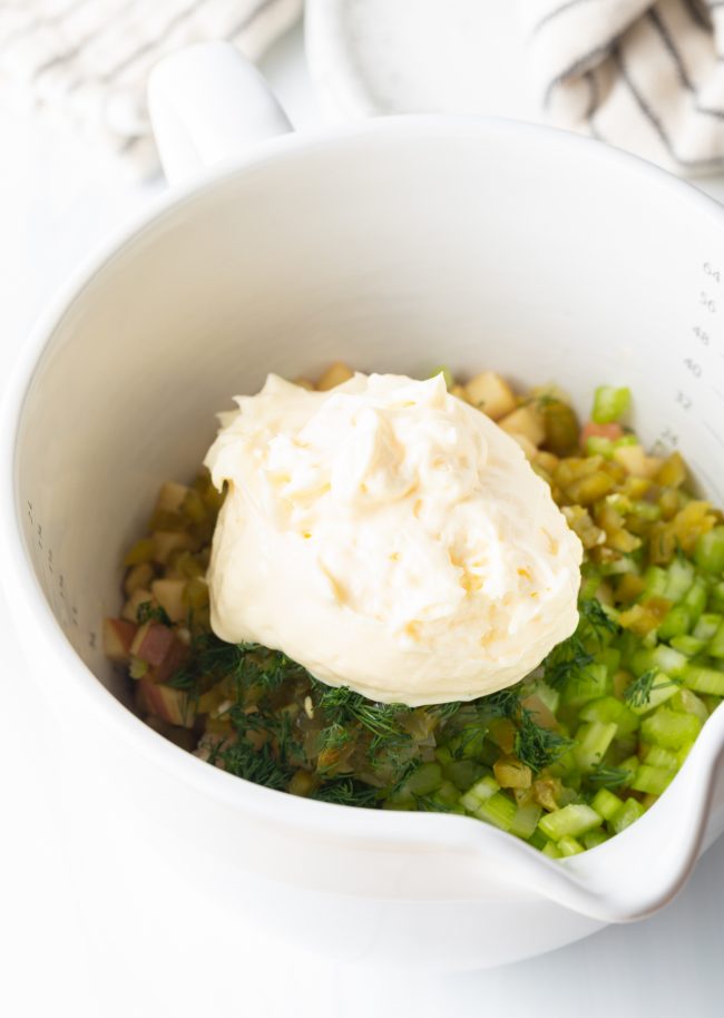 adding dill and mayo to the mixing bowl.