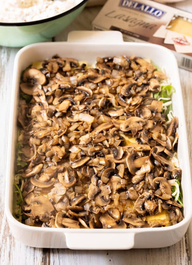 layer mushrooms over vegetable lasagna with white sauce