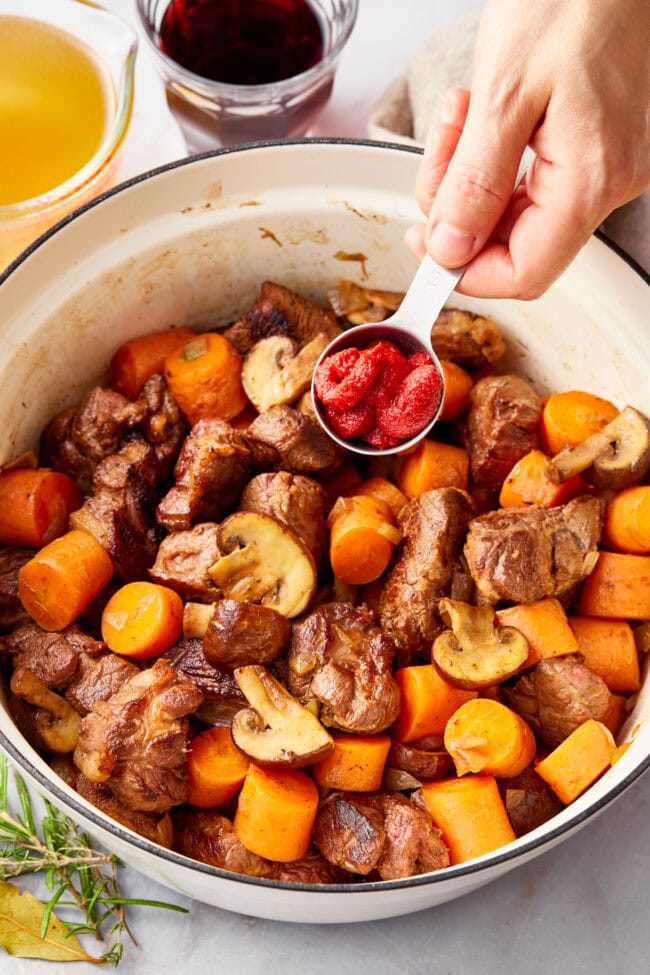 Deer Stew Recipe in a dutch oven with tomato paste added 