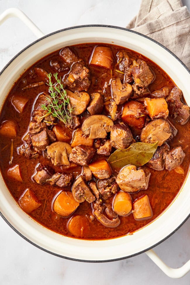 pot of venison bourguignon overhead shot with herbs