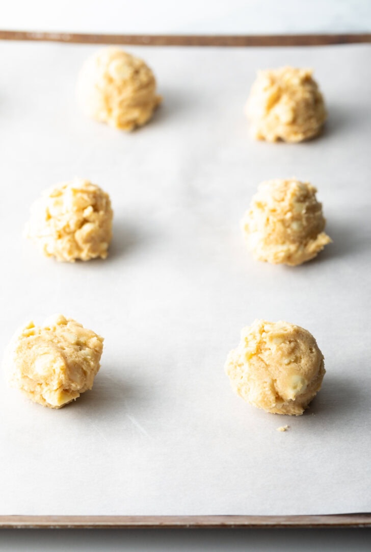 6 balls of cookie dough on parchment paper.