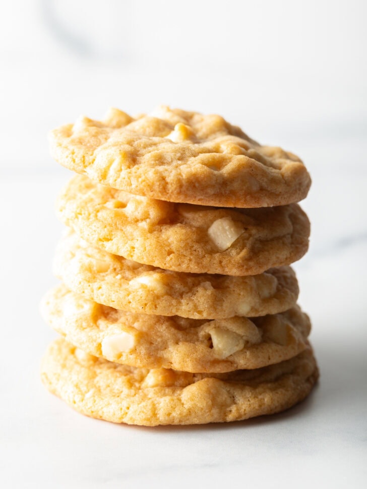 A stack of 5 macadamia nut cookies with white chocolate chips.